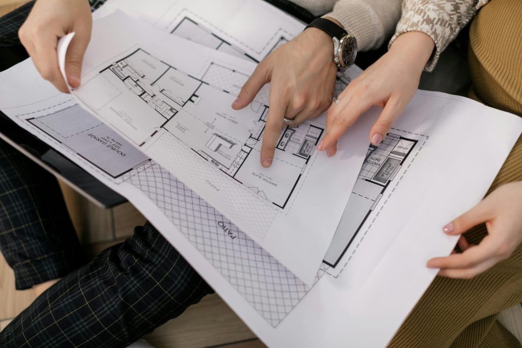 Zwei Personen betrachten Architekturpläne und konzentrieren sich dabei auf die Details des Projekts.